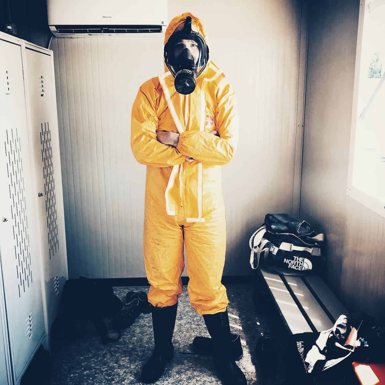 man wearing yellow suit and gas mask