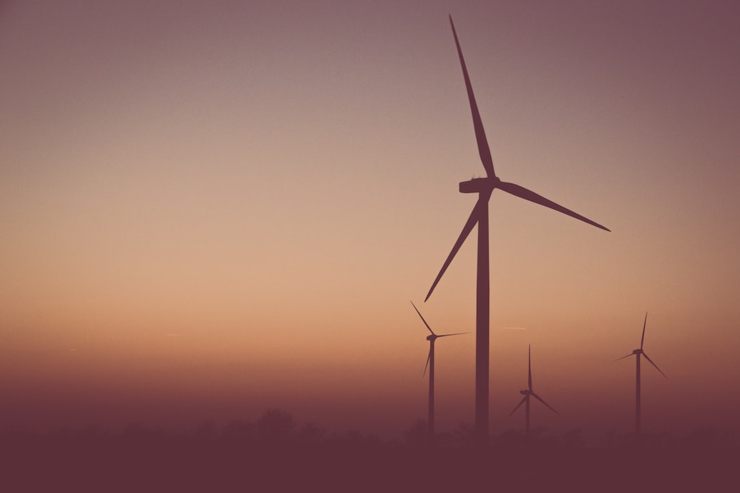 An image showcasing a wind turbine towering over a vast landscape, capturing the dynamic process of energy transfer